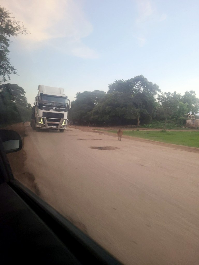 passing a haulage truck on a potholed road